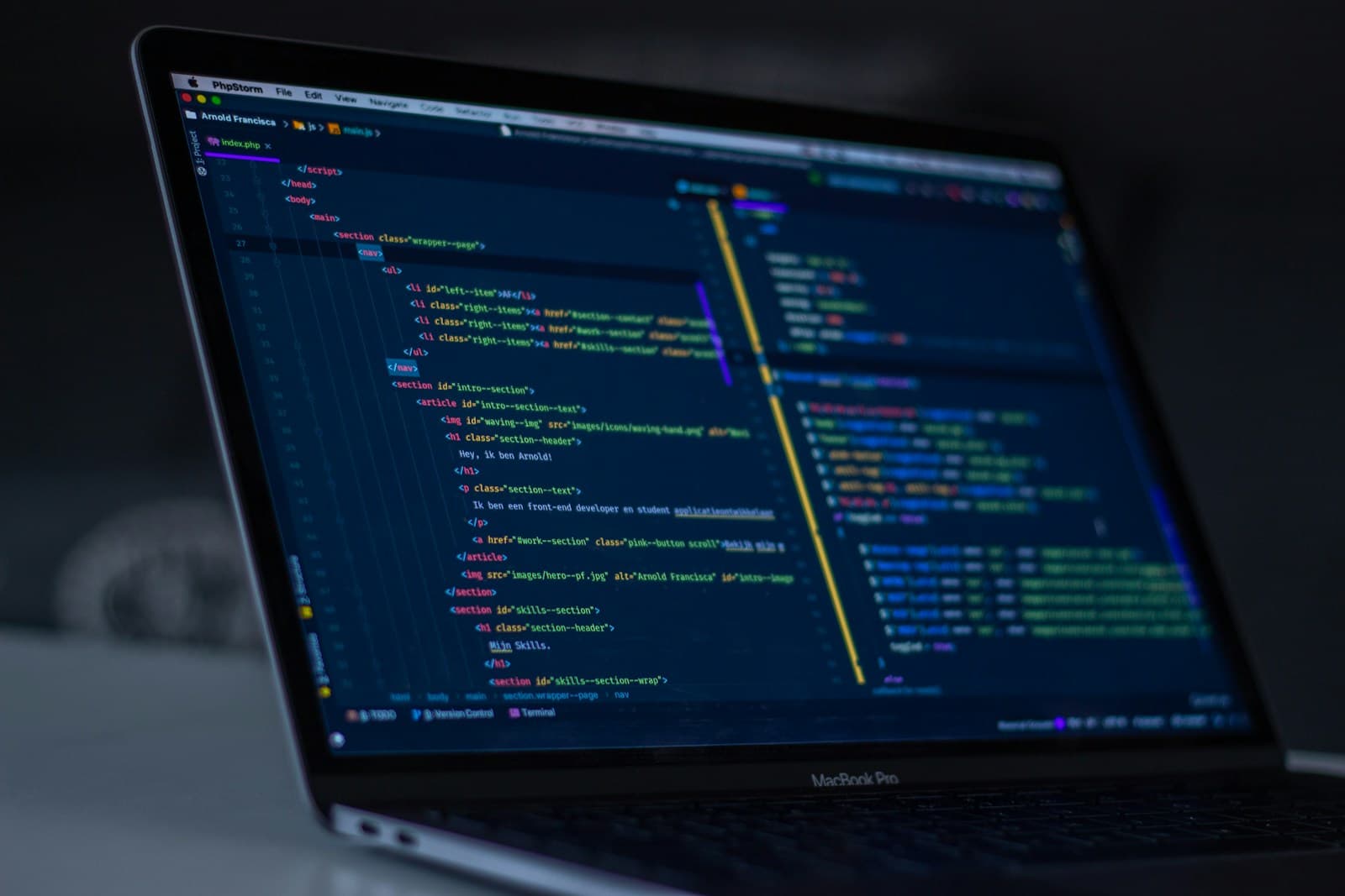 A laptop on a desk showing lines of code on the screen